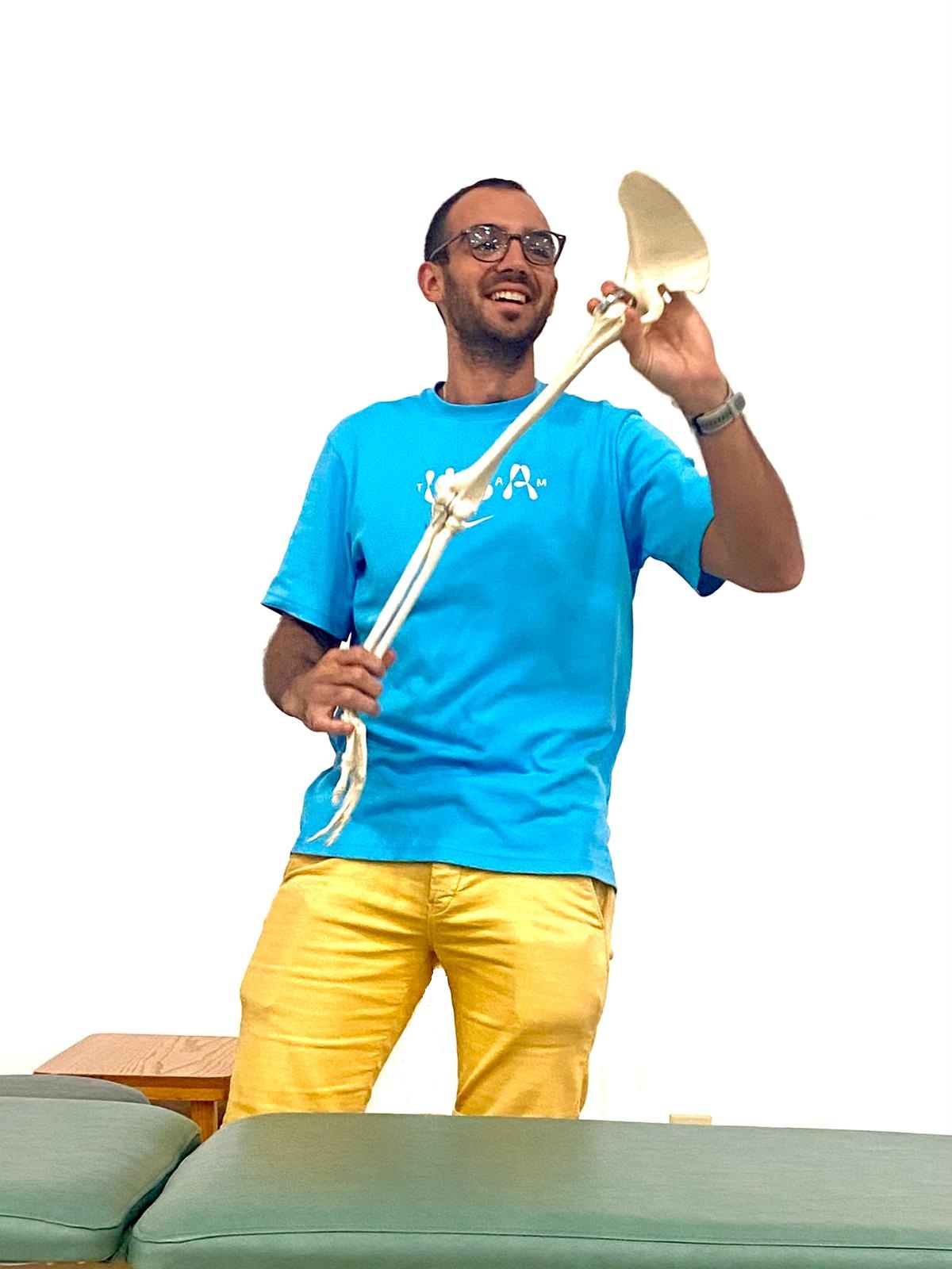 Squelette tenu par ostéopathe en bleu et jaune